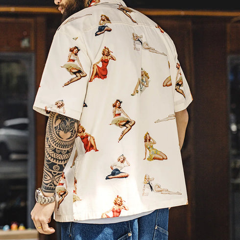 Person wearing a shirt with vintage-style pin-up girl illustrations.
